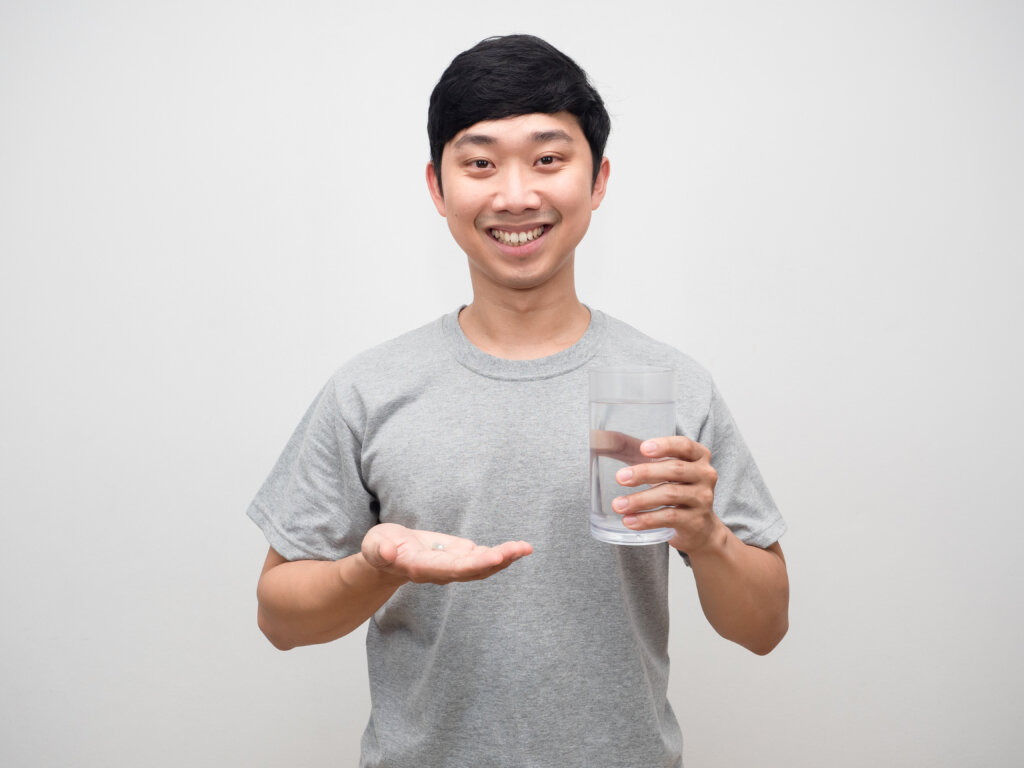 아침 공복에 물 한 잔과 함께 철분 영양제를 섭취하려는 남성, 위산 활성 시간대의 미네랄 흡수 극대화